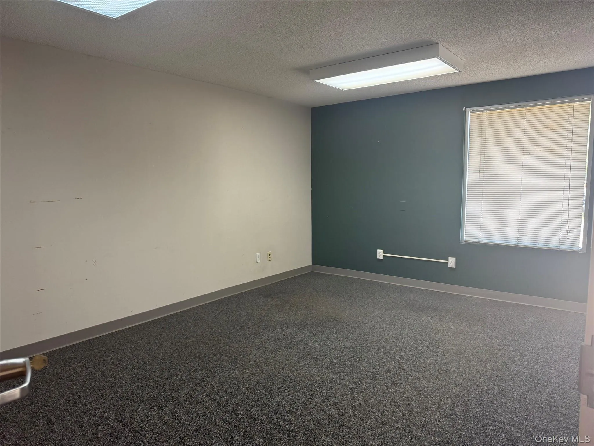 Spare room with a textured ceiling and baseboards Spare room with a textured ceiling and baseboards