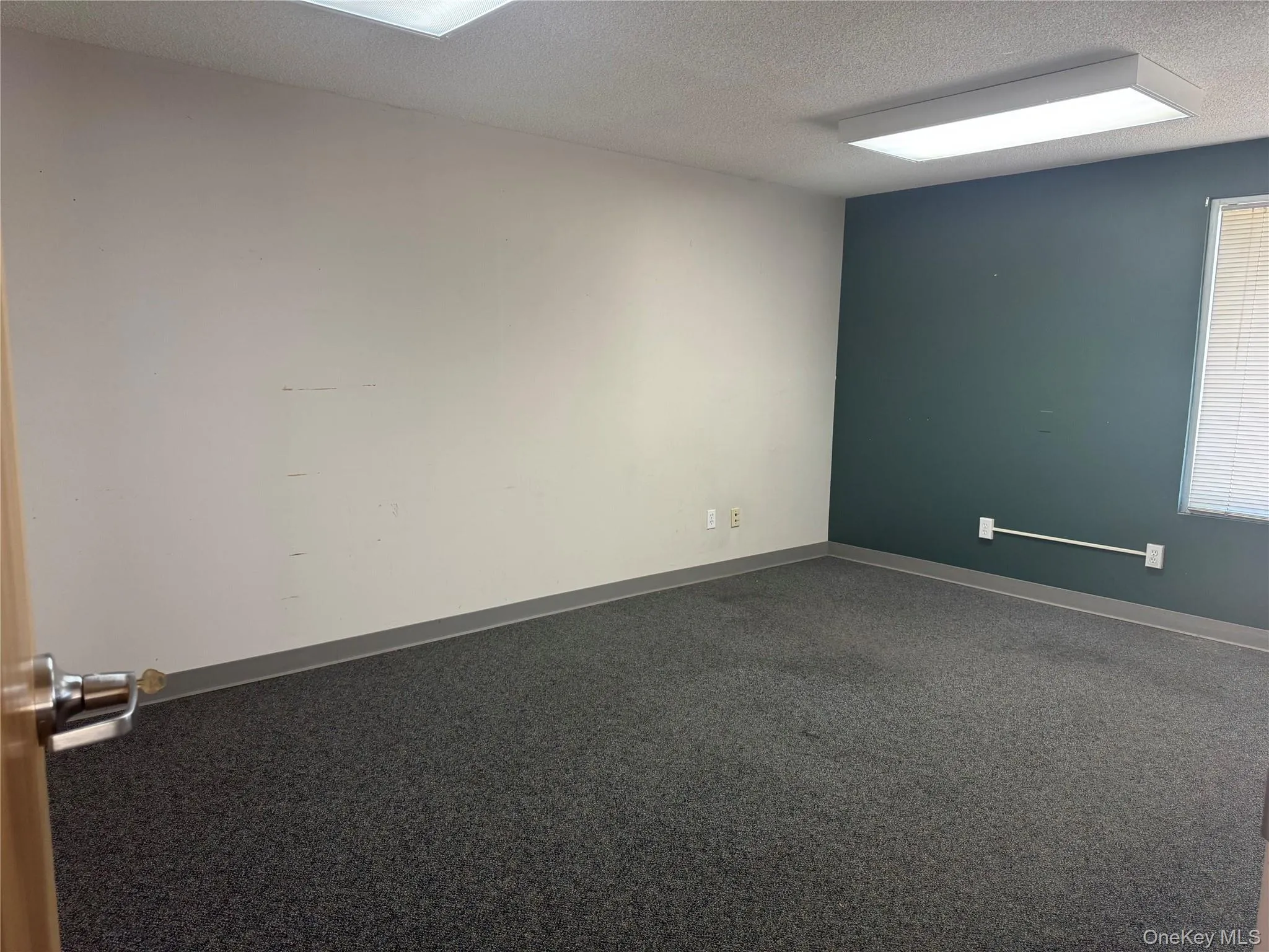 Unfurnished room with a textured ceiling and baseboards Unfurnished room with a textured ceiling and baseboards