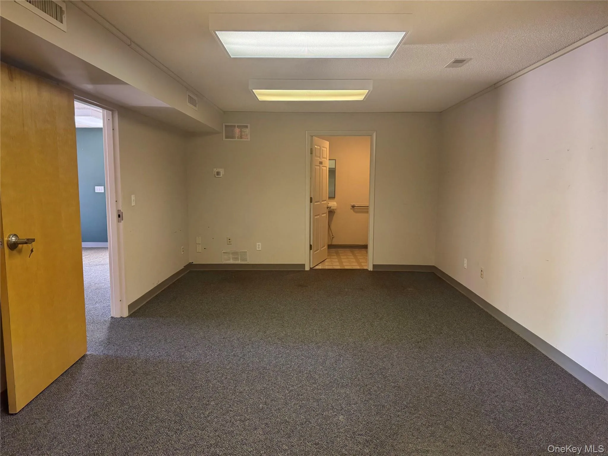 Unfurnished room with baseboards and dark carpet Unfurnished room with baseboards and dark carpet