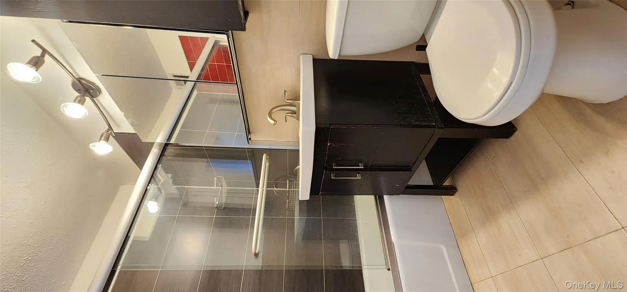 Full bath with enclosed tub / shower combo, vanity, a textured ceiling, and light tile patterned floors Full bath with enclosed tub / shower combo, vanity, a textured ceiling, and light tile patterned floors