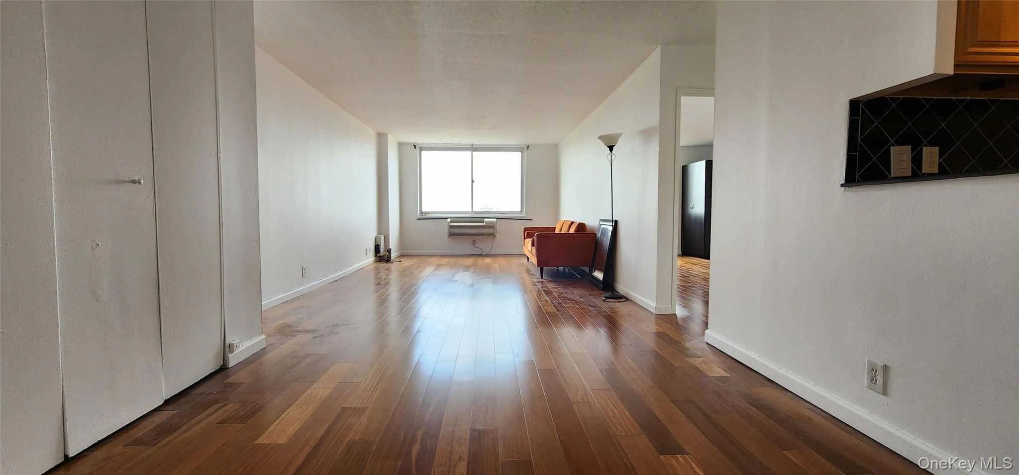 Unfurnished living room with dark wood finished floors and baseboards Unfurnished living room with dark wood finished floors and baseboards