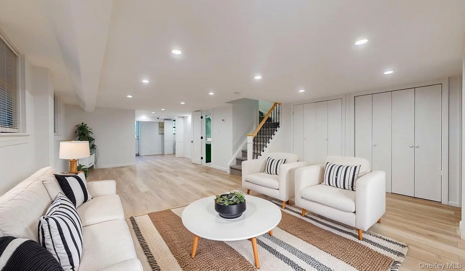 Living area with stairs, light wood finished floors, and recessed lighting Living area with stairs, light wood finished floors, and recessed lighting