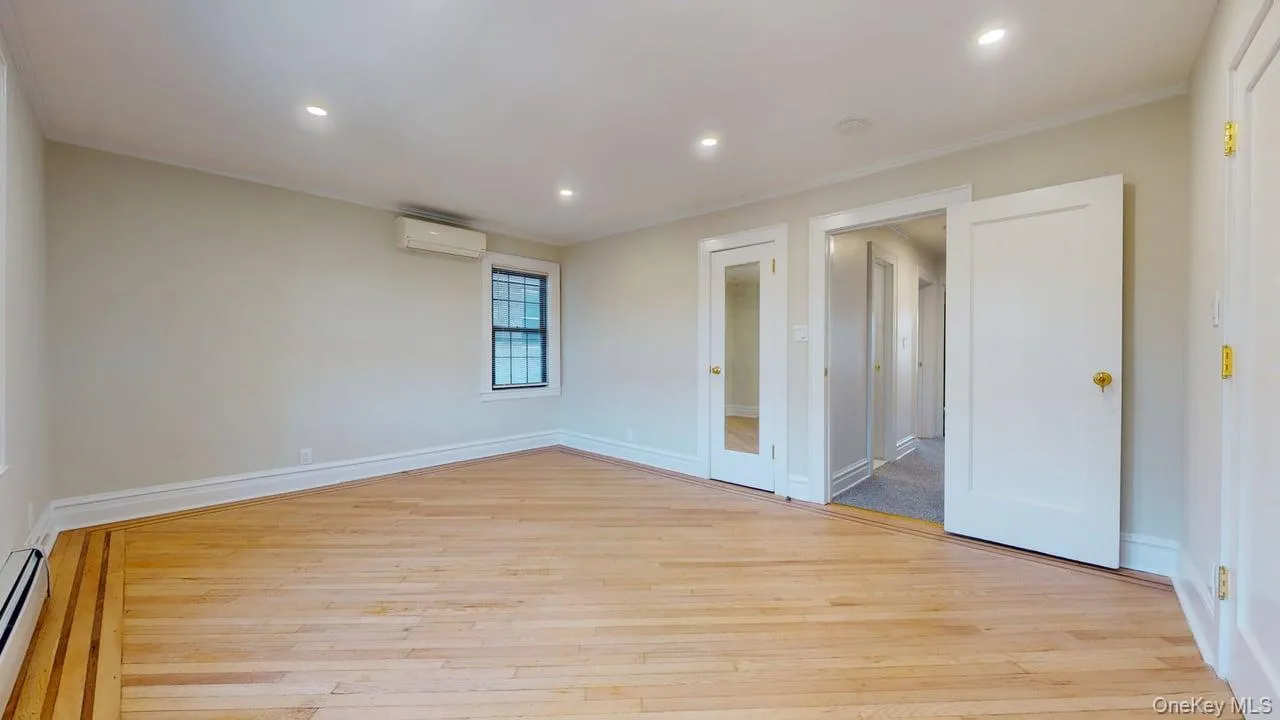 Spare room featuring light wood-style flooring, recessed lighting, crown molding, a wall unit AC, and a baseboard radiator Spare room featuring light wood-style flooring, recessed lighting, crown molding, a wall unit AC, and a baseboard radiator