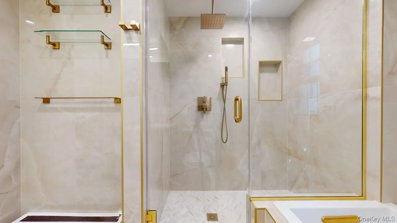 Bathroom featuring a marble finish shower and a bathtub Bathroom featuring a marble finish shower and a bathtub