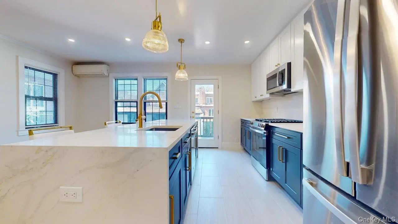 Kitchen featuring stainless steel appliances, white cabinetry, decorative light fixtures, light stone counters, and recessed lighting Kitchen featuring stainless steel appliances, white cabinetry, decorative light fixtures, light stone counters, and recessed lighting