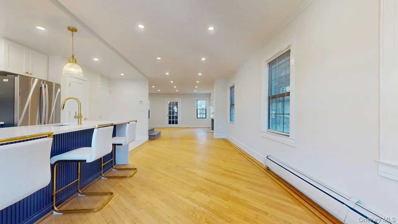 Kitchen with a baseboard radiator, hanging light fixtures, freestanding refrigerator, light wood-style flooring, and recessed lighting Kitchen with a baseboard radiator, hanging light fixtures, freestanding refrigerator, light wood-style flooring, and recessed lighting