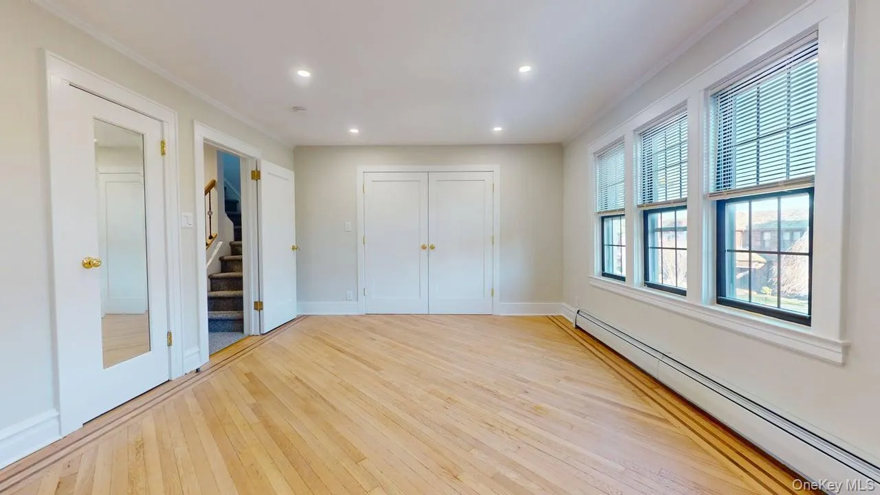 Unfurnished bedroom with a baseboard heating unit, light wood finished floors, a closet, ornamental molding, and recessed lighting Unfurnished bedroom with a baseboard heating unit, light wood finished floors, a closet, ornamental molding, and recessed lighting
