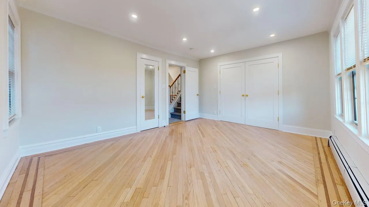 Unfurnished bedroom with baseboard heating, light wood-style flooring, recessed lighting, and a closet Unfurnished bedroom with baseboard heating, light wood-style flooring, recessed lighting, and a closet