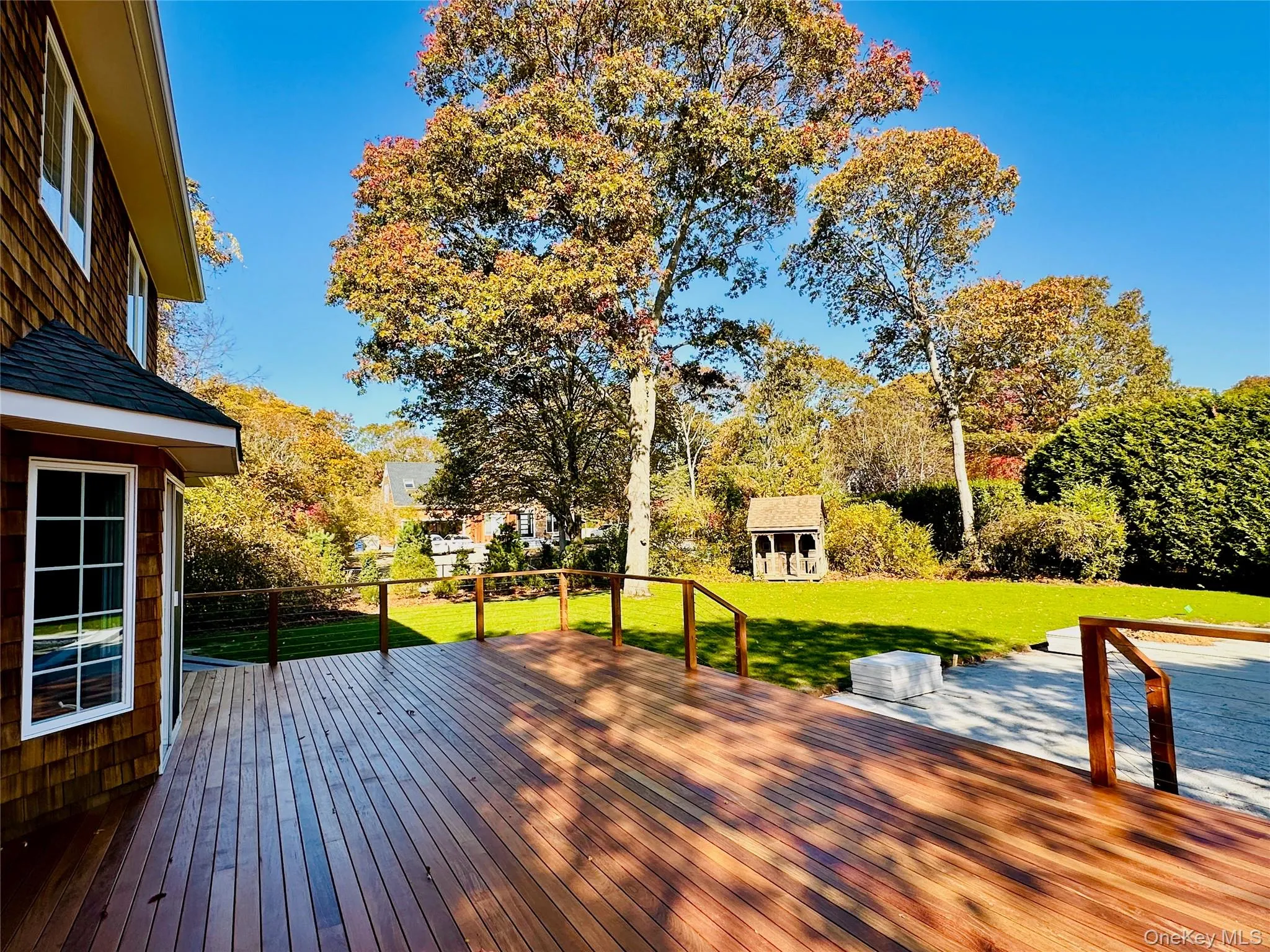 Deck featuring an outbuilding, a lawn, and view of wooded area Deck featuring an outbuilding, a lawn, and view of wooded area