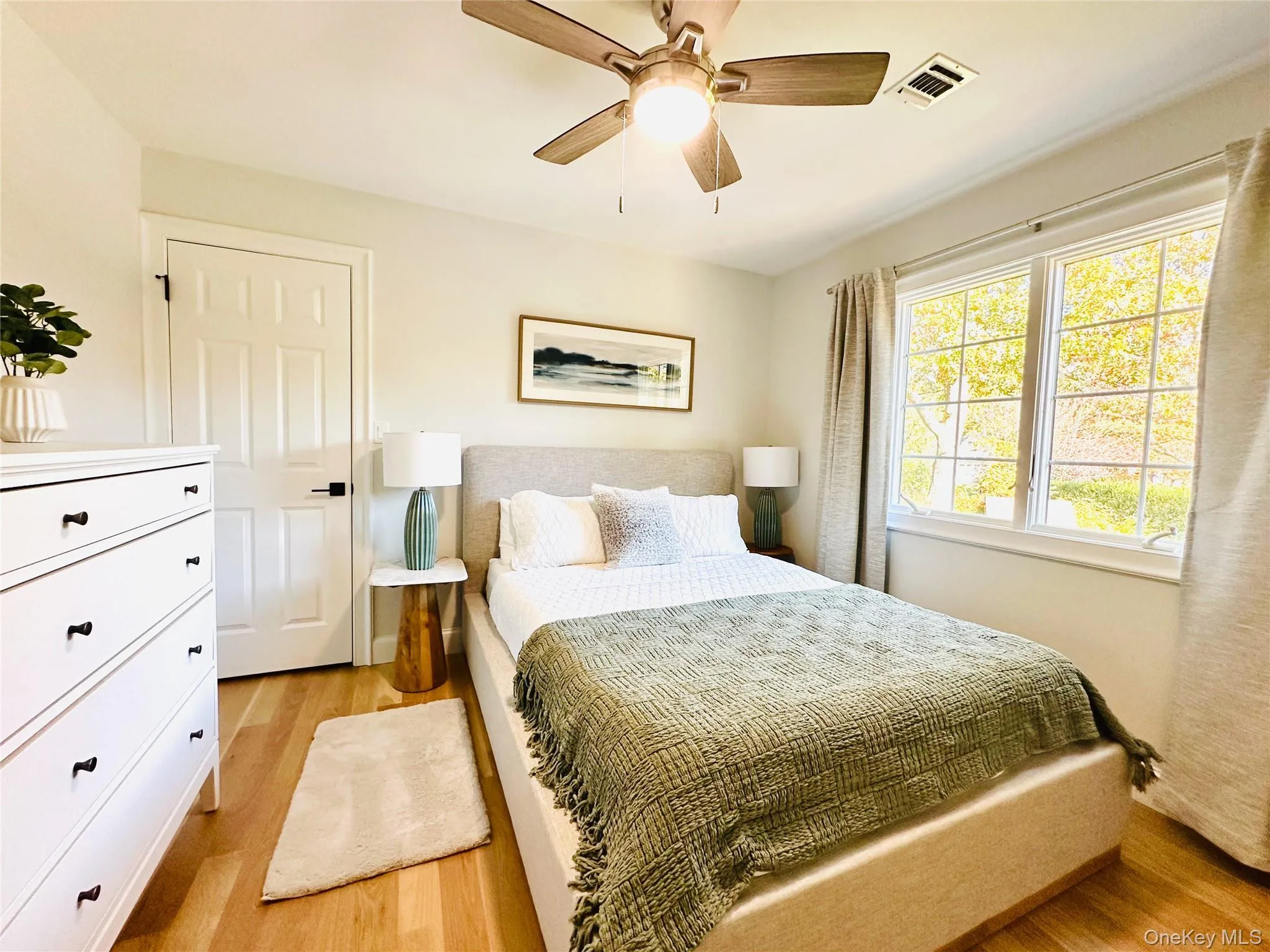 Bedroom with light wood-style flooring and a ceiling fan Bedroom with light wood-style flooring and a ceiling fan