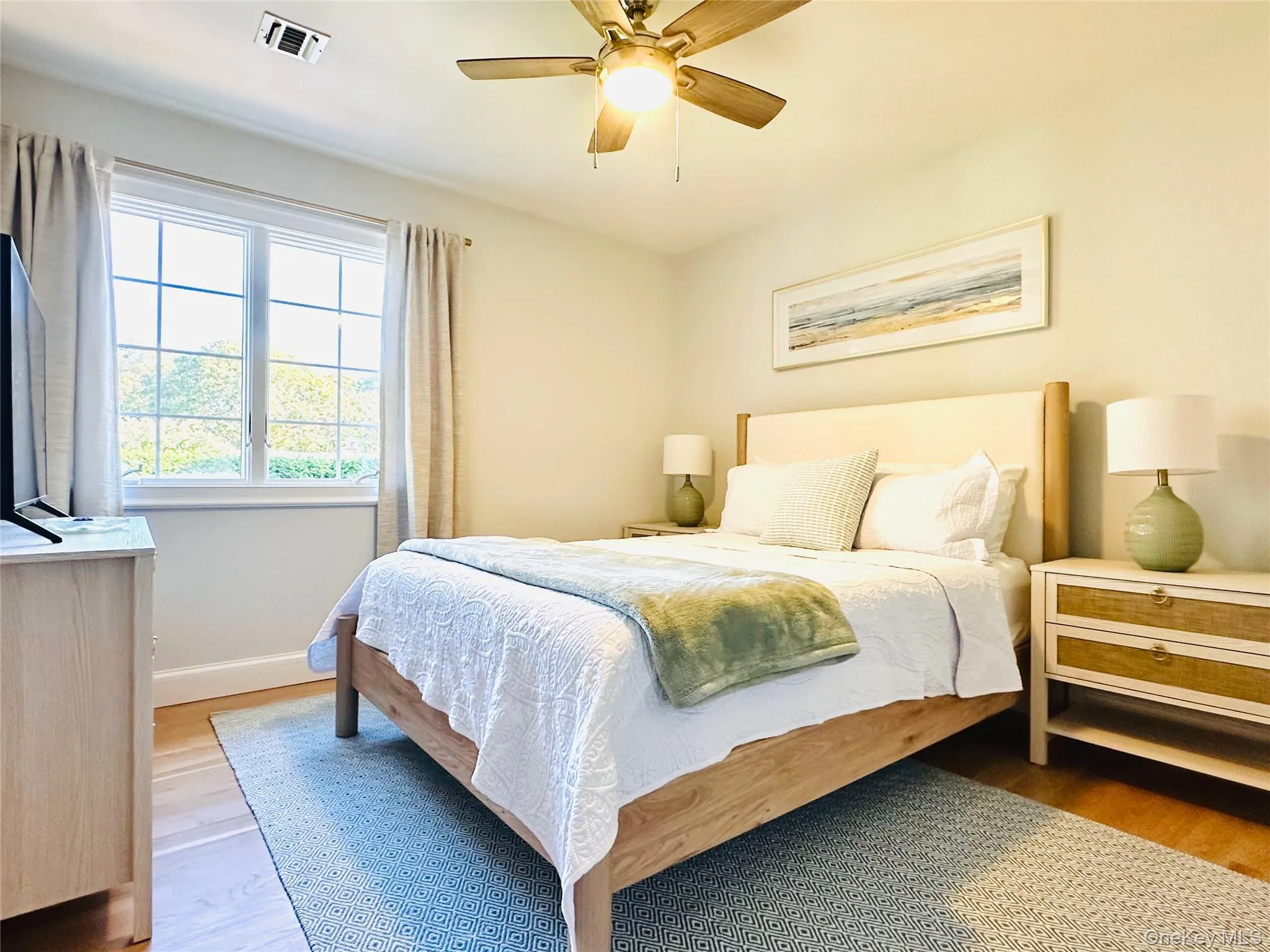 Bedroom featuring light wood finished floors and ceiling fan Bedroom featuring light wood finished floors and ceiling fan