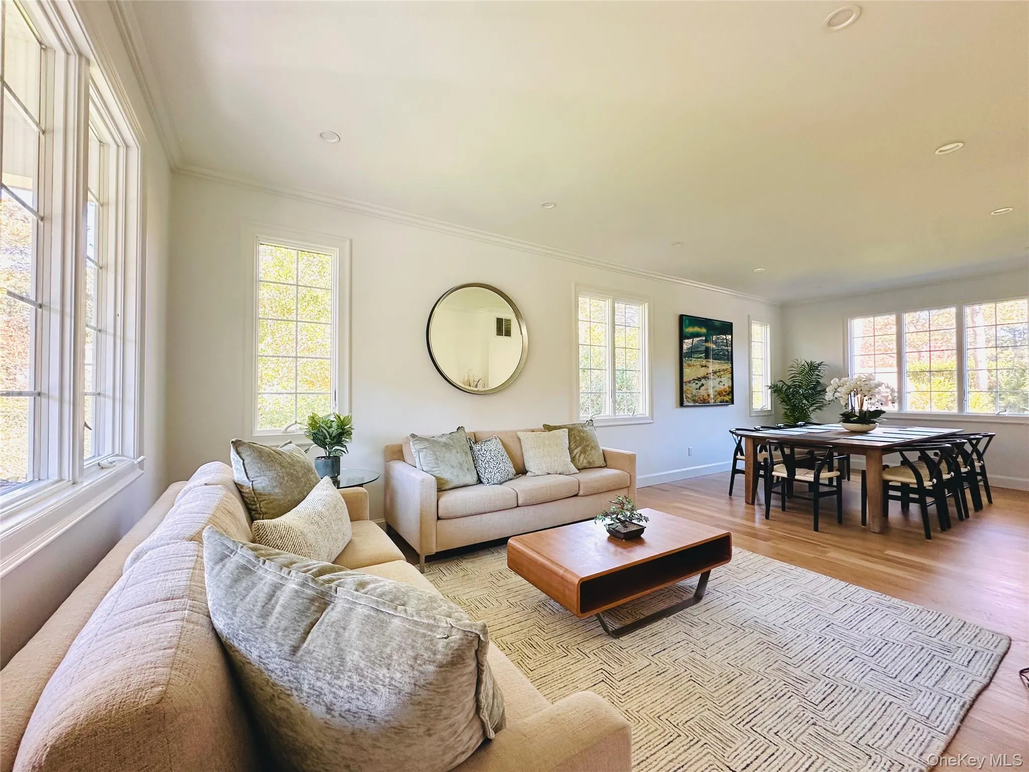 Living area featuring ornamental molding, light wood-type flooring, healthy amount of natural light, and recessed lighting Living area featuring ornamental molding, light wood-type flooring, healthy amount of natural light, and recessed lighting