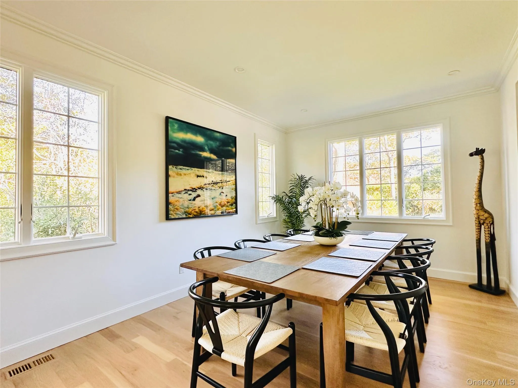 Dining room featuring light wood-type flooring and ornamental molding Dining room featuring light wood-type flooring and ornamental molding