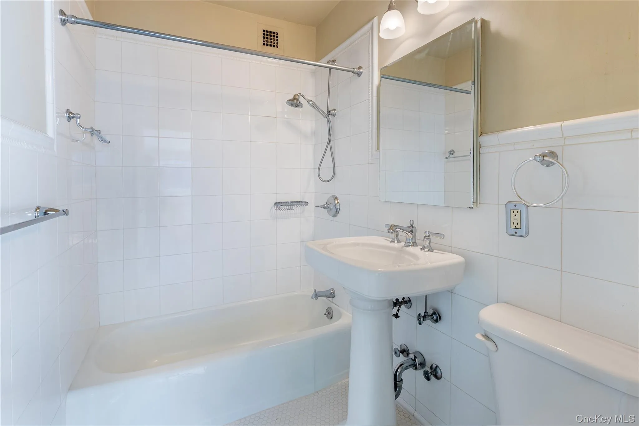 Full bathroom with bathtub / shower combination and tile walls Full bathroom with bathtub / shower combination and tile walls