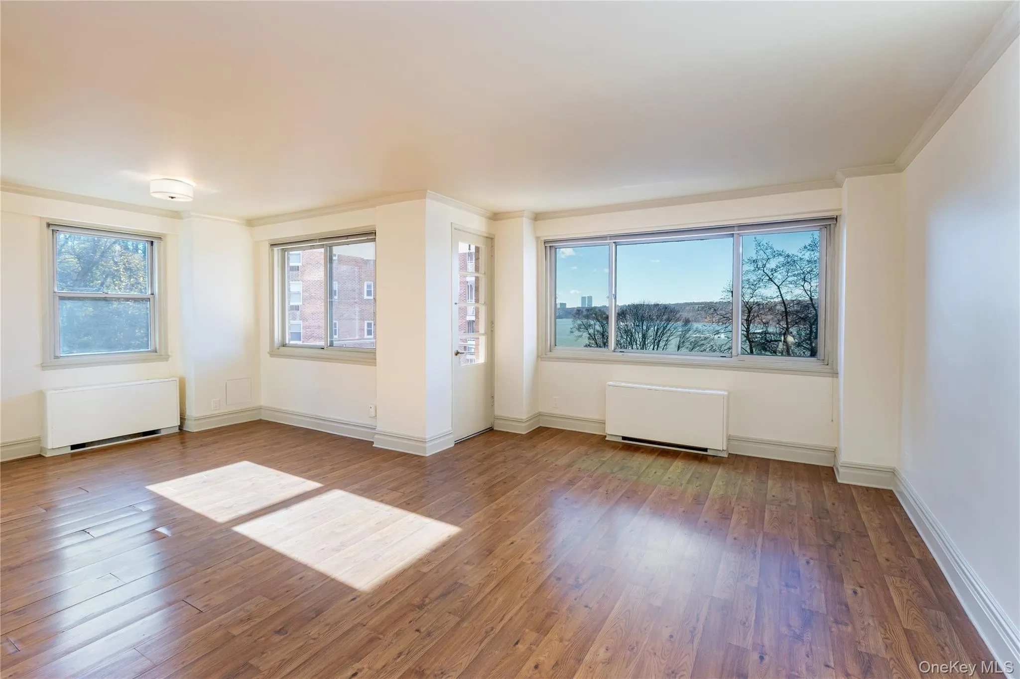 Unfurnished room with radiator heating unit, hardwood / wood-style floors, and crown molding Unfurnished room with radiator heating unit, hardwood / wood-style floors, and crown molding