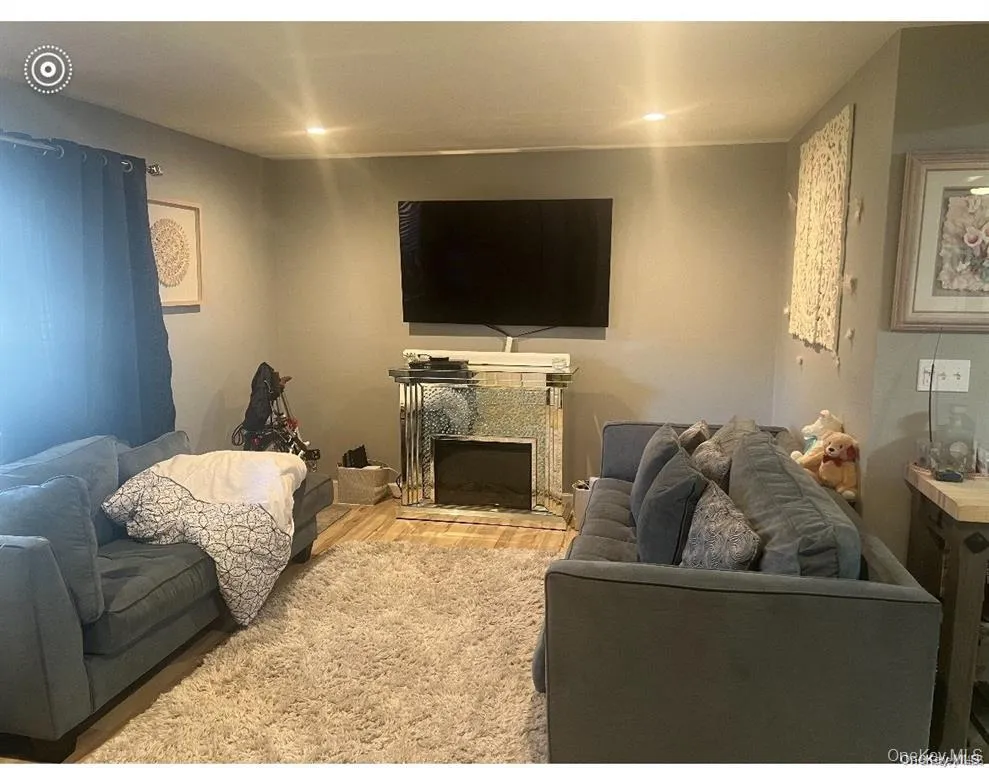 Living room with a premium fireplace and wood finished floors Living room with a premium fireplace and wood finished floors