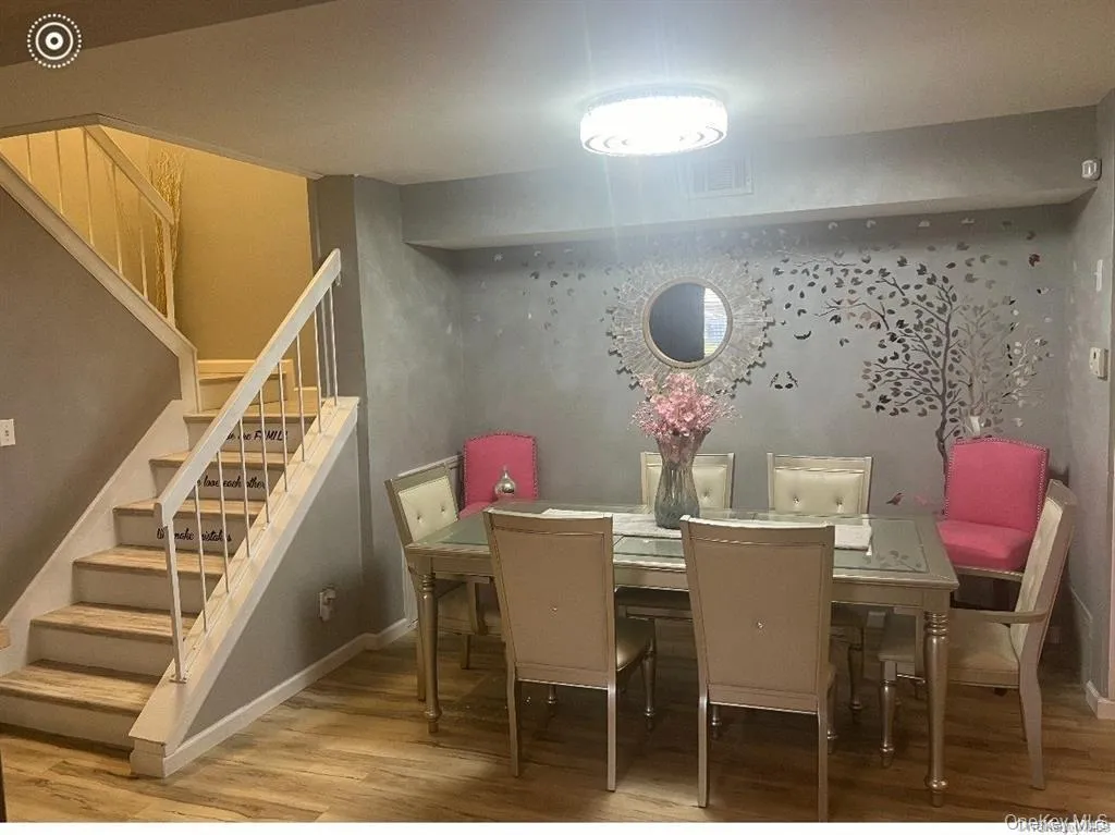 Dining room featuring light wood-type flooring and stairs Dining room featuring light wood-type flooring and stairs