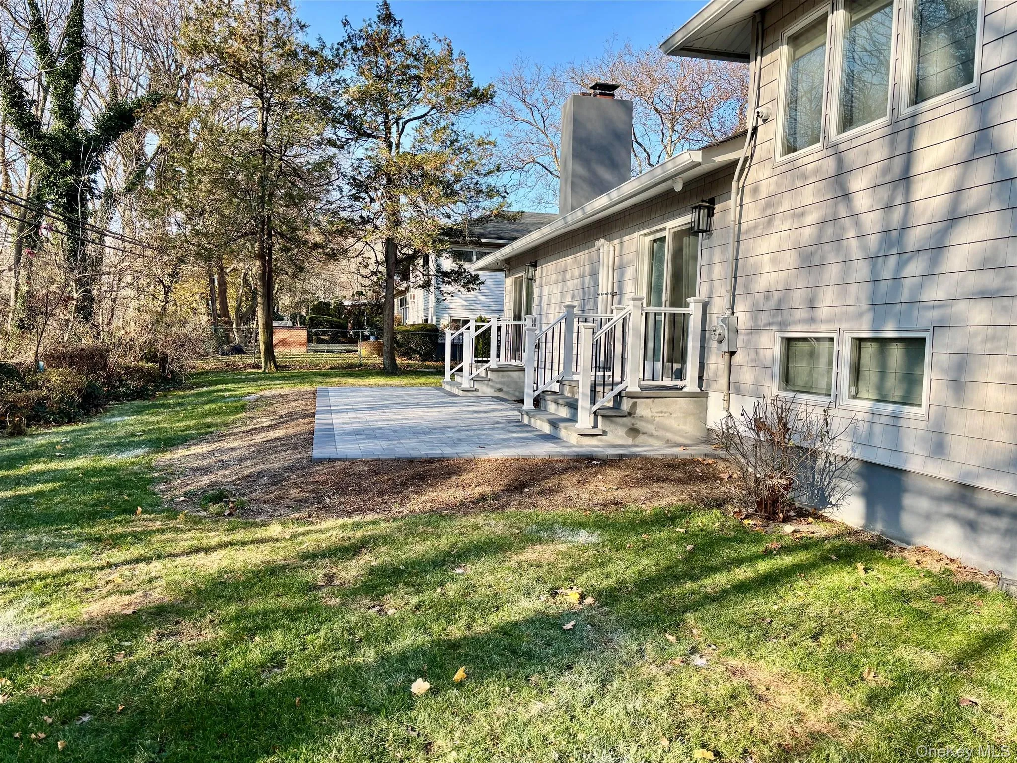 View of grassy yard featuring a patio area View of grassy yard featuring a patio area