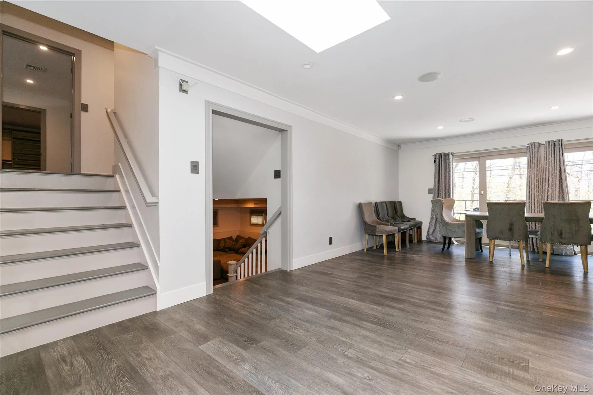 Living area featuring recessed lighting, ornamental molding, stairs, and a skylight Living area featuring recessed lighting, ornamental molding, stairs, and a skylight