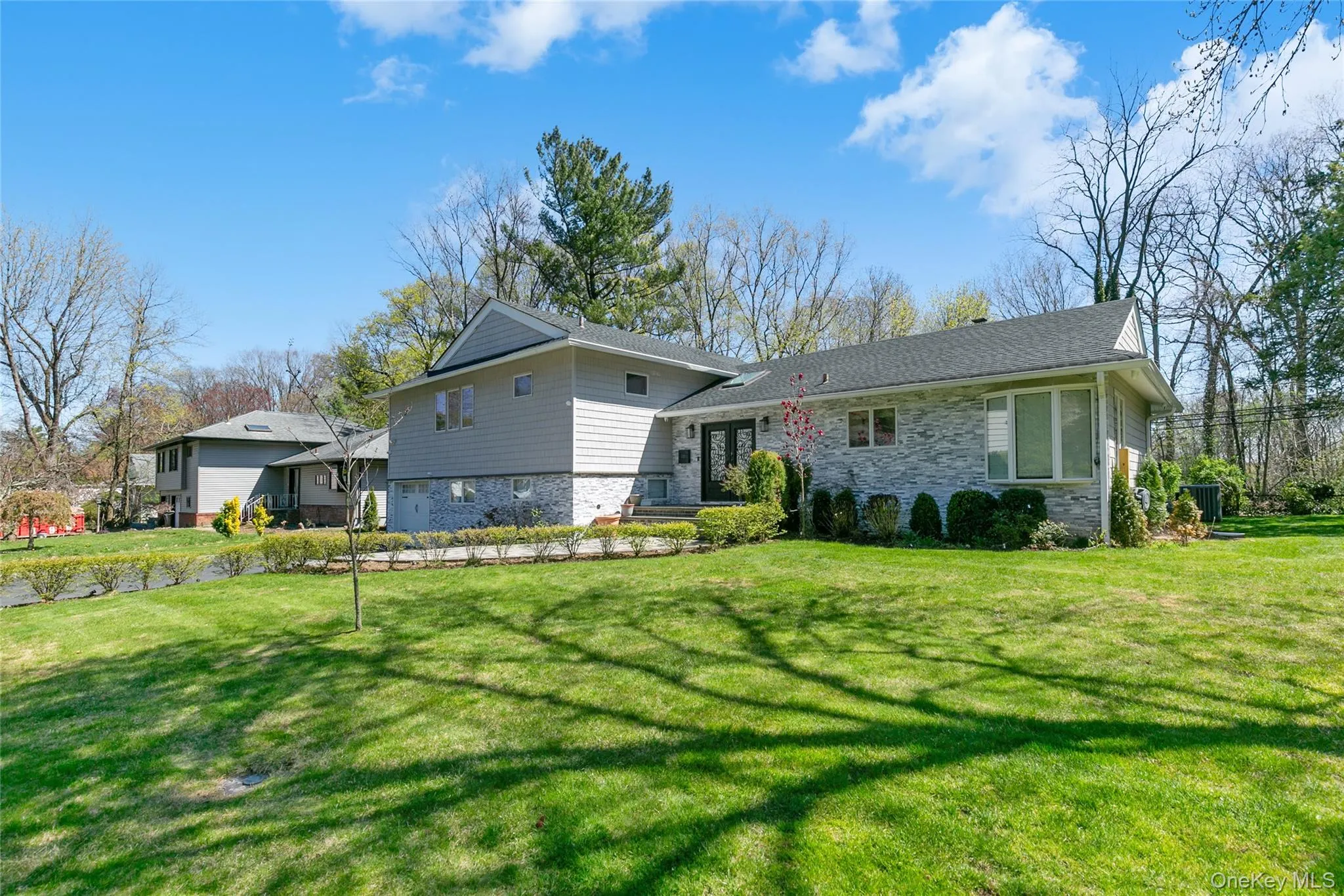 Rear view of property featuring stone siding and a yard Rear view of property featuring stone siding and a yard