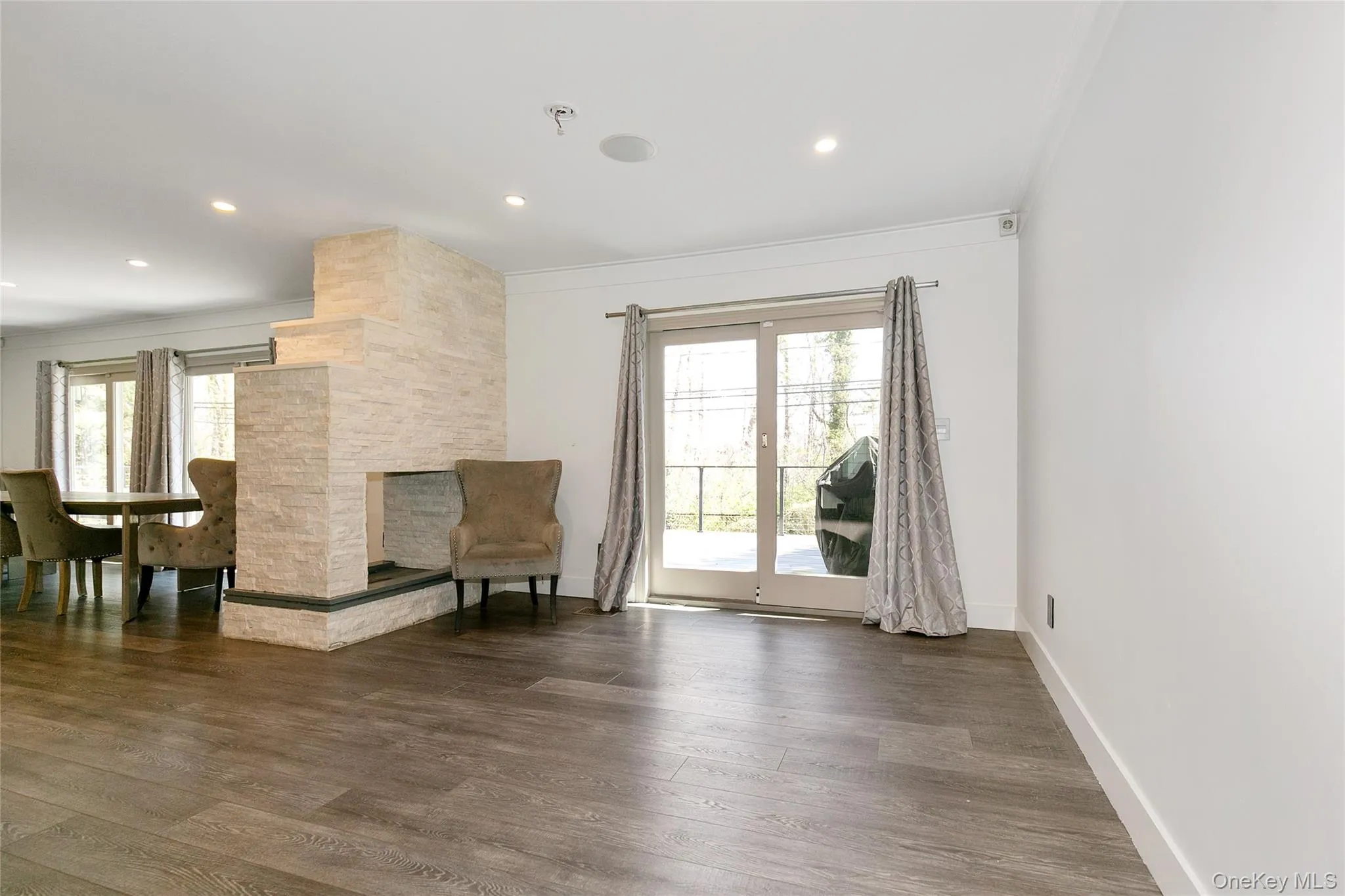Sitting room with wood finished floors, ornamental molding, and recessed lighting Sitting room with wood finished floors, ornamental molding, and recessed lighting