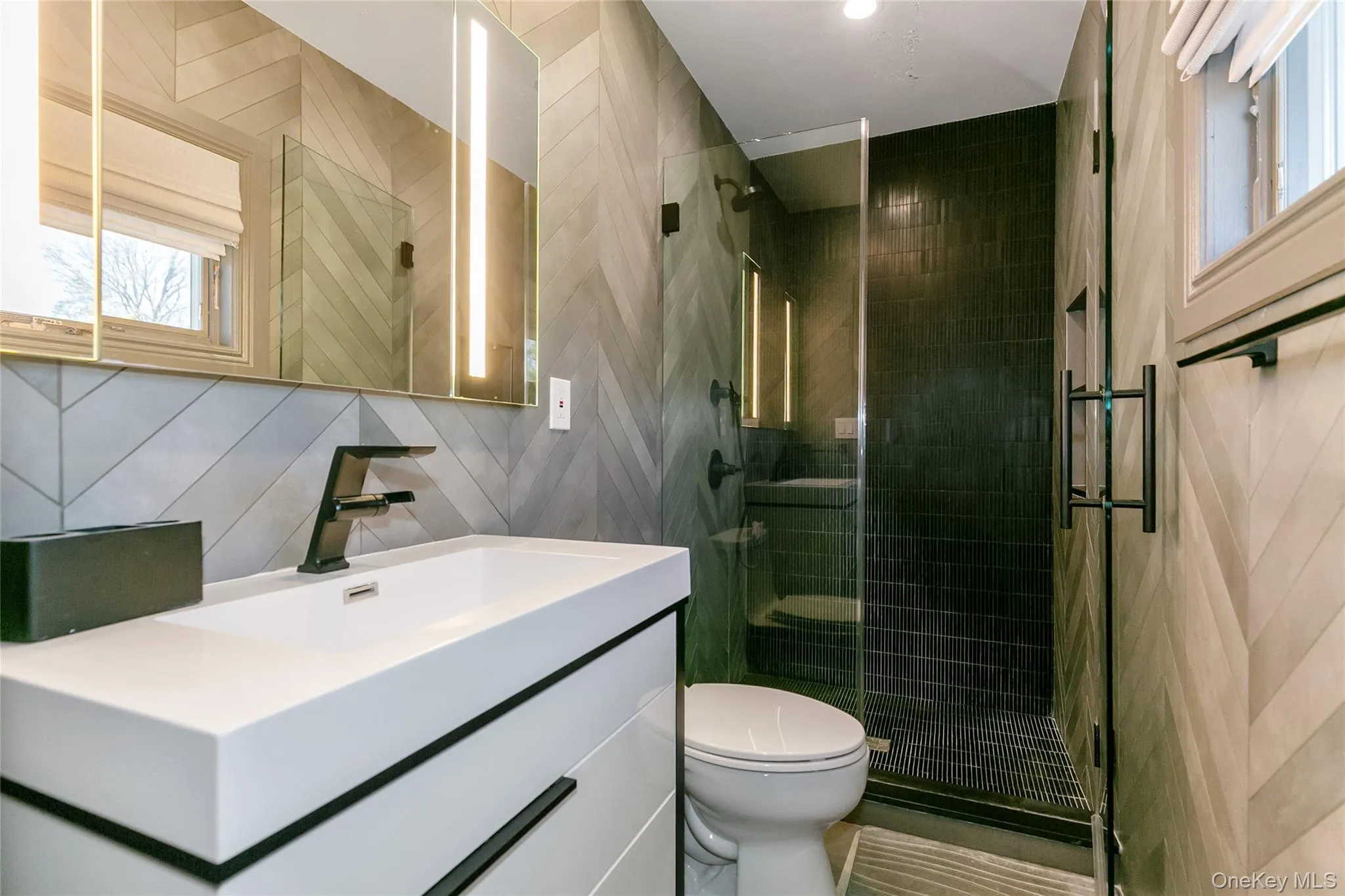 Full bath with vanity, walk in shower, and tile walls Full bath with vanity, walk in shower, and tile walls