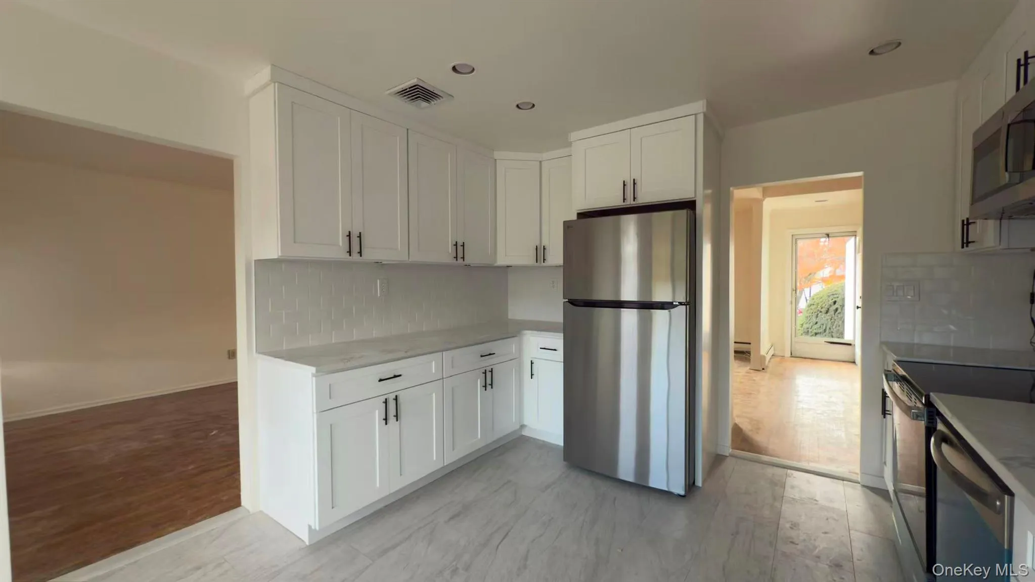 Kitchen featuring stainless steel appliances, backsplash, white cabinetry, and recessed lighting Kitchen featuring stainless steel appliances, backsplash, white cabinetry, and recessed lighting