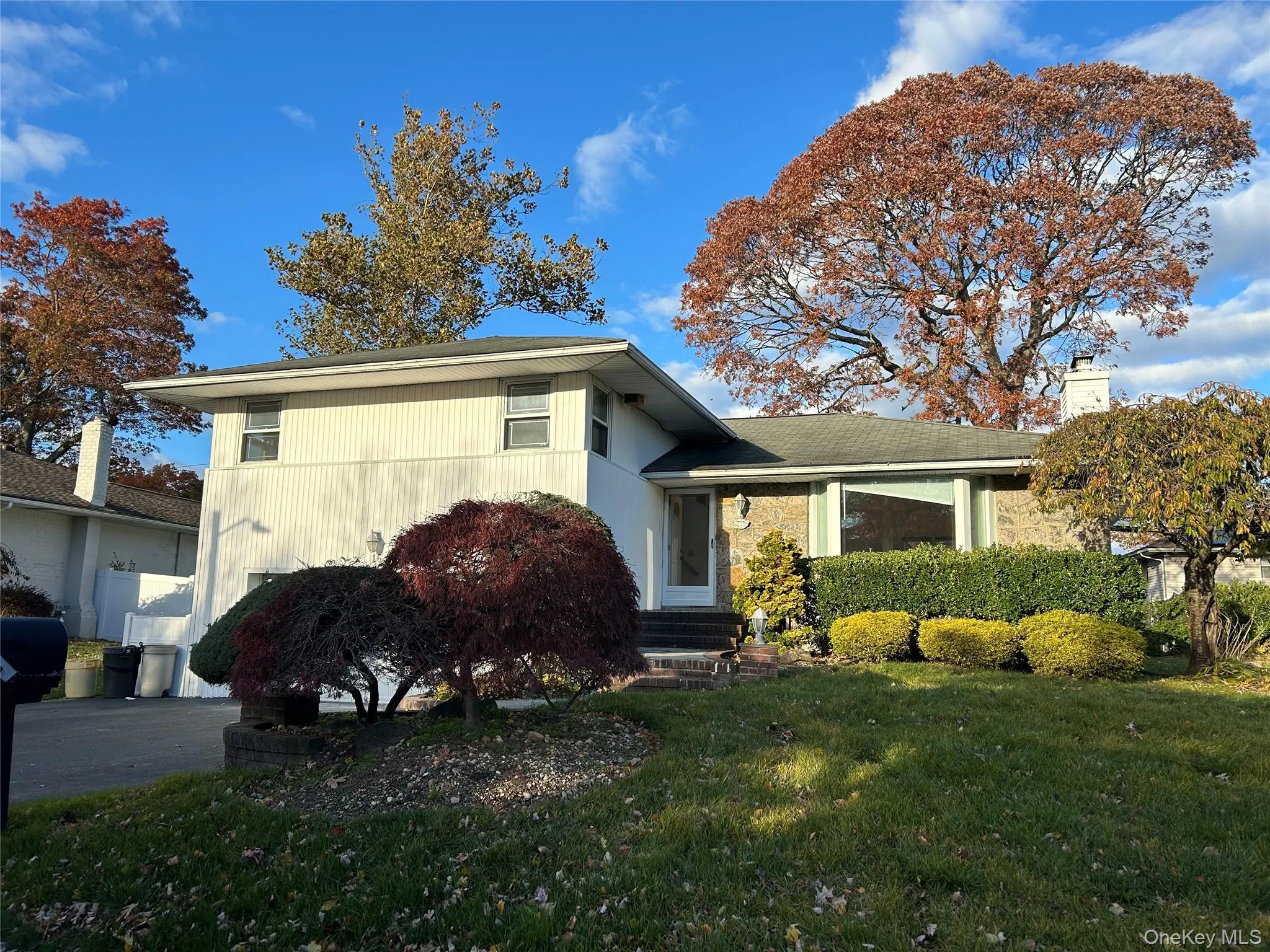 Split level home with a front lawn and a chimney Split level home with a front lawn and a chimney