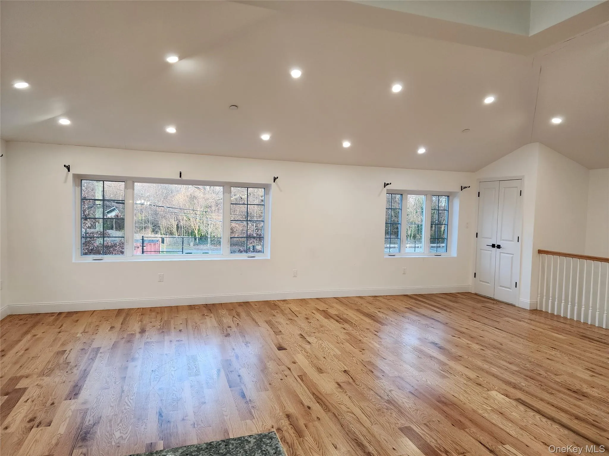 Empty room featuring recessed lighting, light wood-style floors, and vaulted ceiling Empty room featuring recessed lighting, light wood-style floors, and vaulted ceiling
