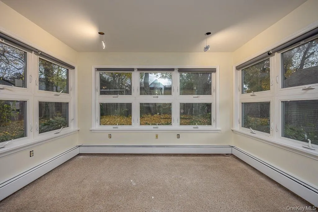Unfurnished sunroom with a baseboard heating unit and plenty of natural light Unfurnished sunroom with a baseboard heating unit and plenty of natural light