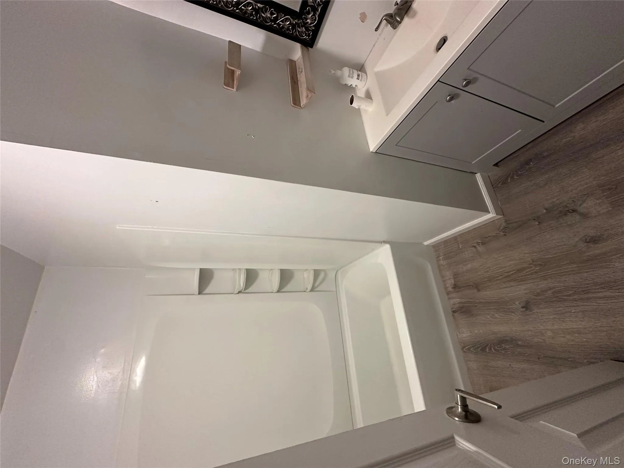 Full bath with vanity, dark wood finished floors, and bathing tub / shower combination Full bath with vanity, dark wood finished floors, and bathing tub / shower combination