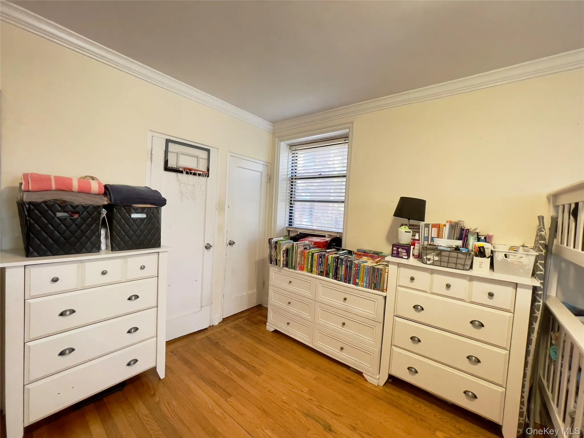 Bedroom with ornamental molding and light wood-style flooring Bedroom with ornamental molding and light wood-style flooring