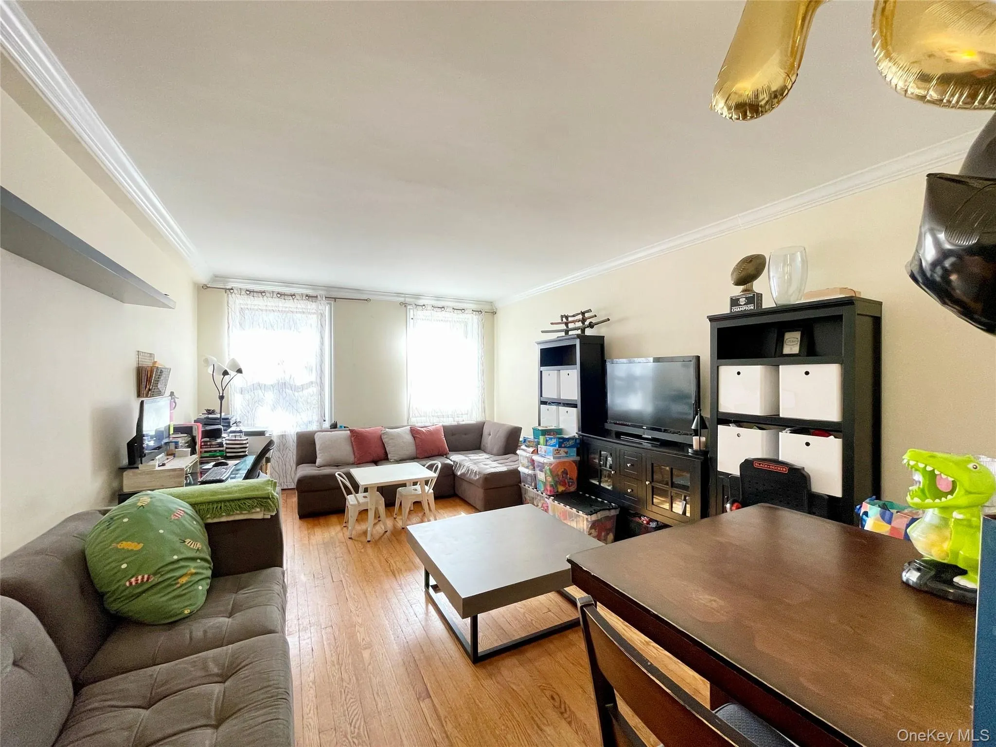 Living area with crown molding and wood-type flooring Living area with crown molding and wood-type flooring