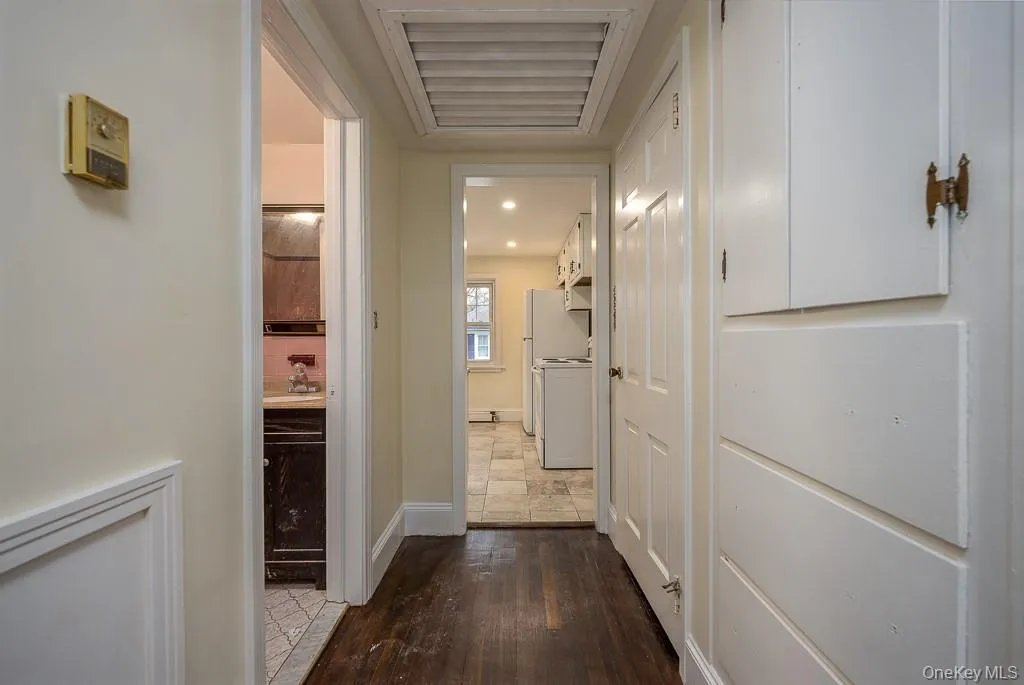 Corridor featuring dark wood finished floors and baseboards Corridor featuring dark wood finished floors and baseboards
