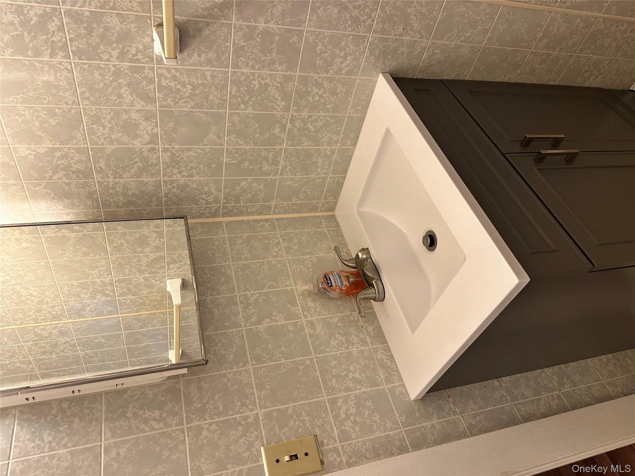 Bathroom featuring vanity and tile walls Bathroom featuring vanity and tile walls