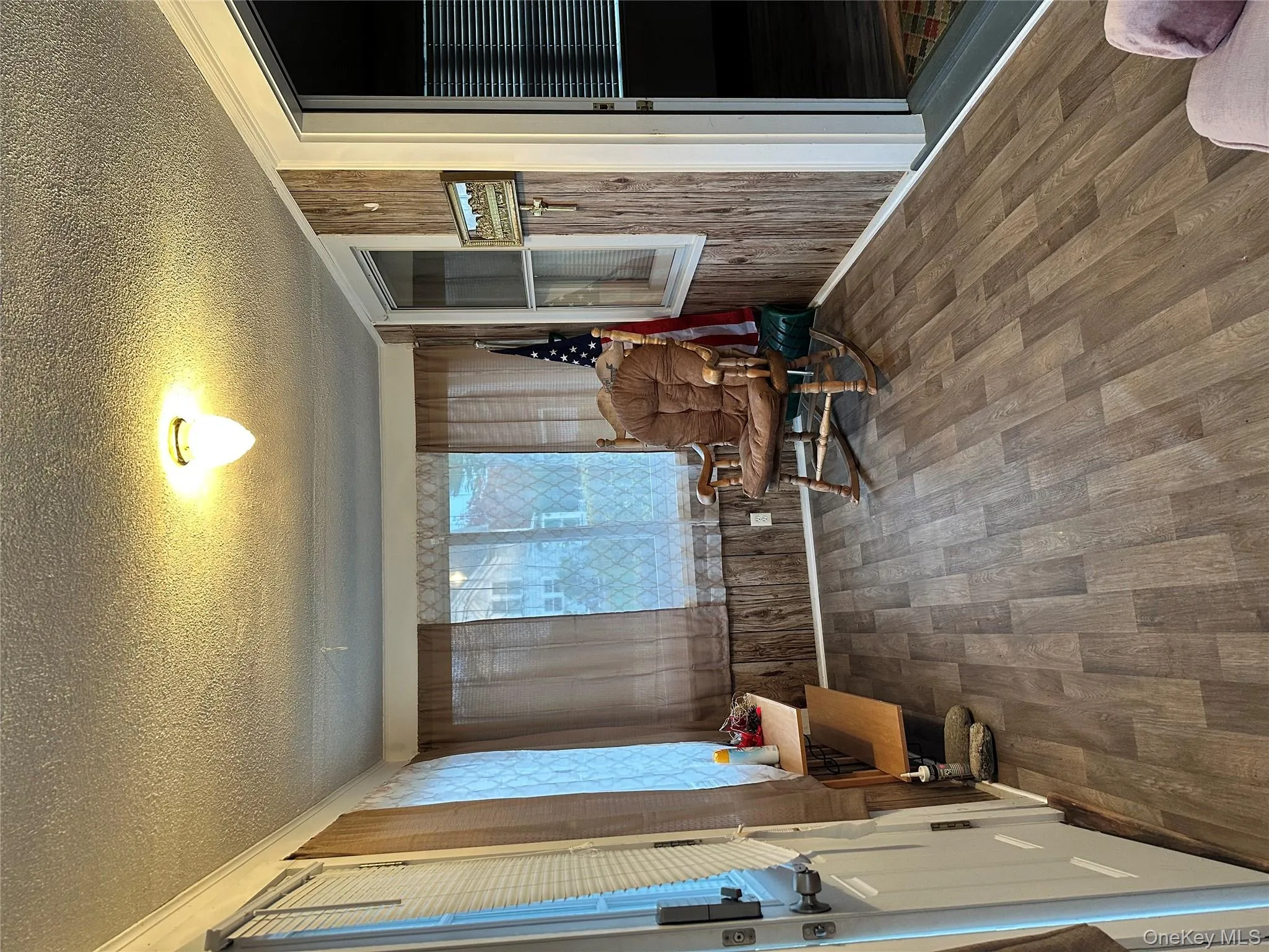 Sitting room featuring wood finished floors, a textured ceiling, and wood walls Sitting room featuring wood finished floors, a textured ceiling, and wood walls