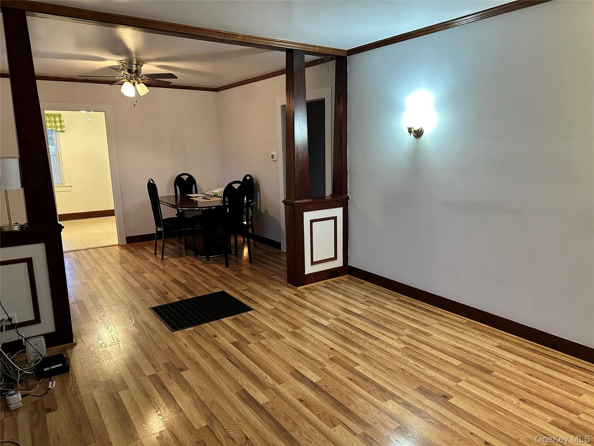 Living room featuring ornamental molding, and light wood-style flooring. Living room featuring ornamental molding, and light wood-style flooring.