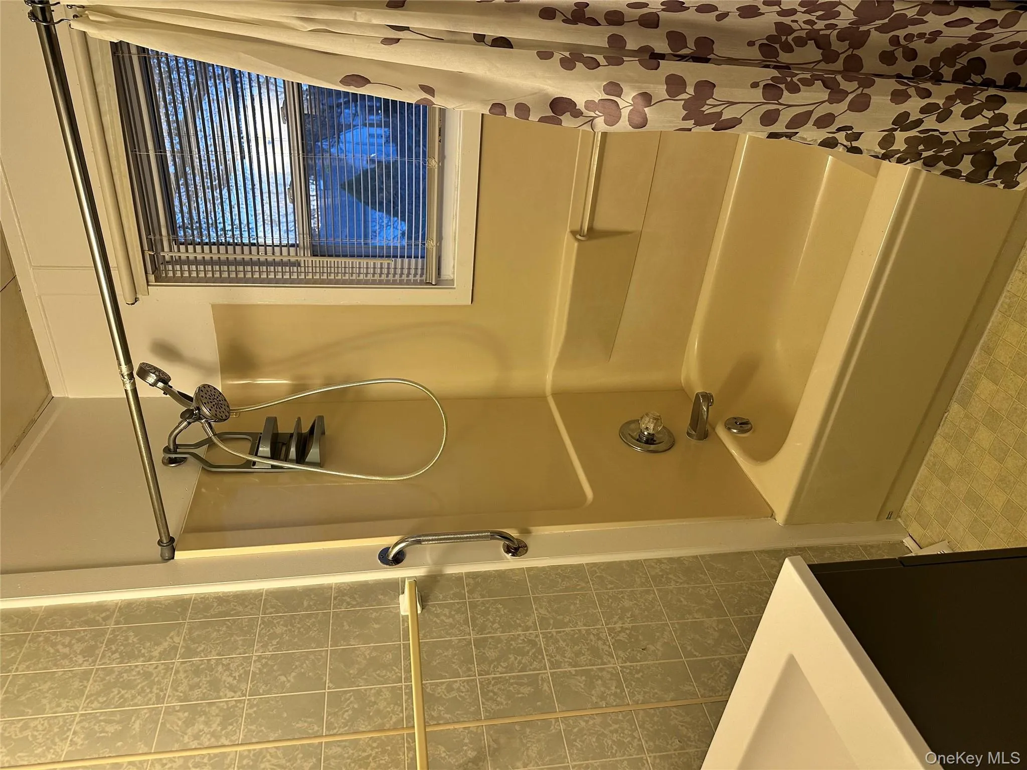 Bathroom featuring shower / bath combo with shower curtain, tile walls, and vanity Bathroom featuring shower / bath combo with shower curtain, tile walls, and vanity