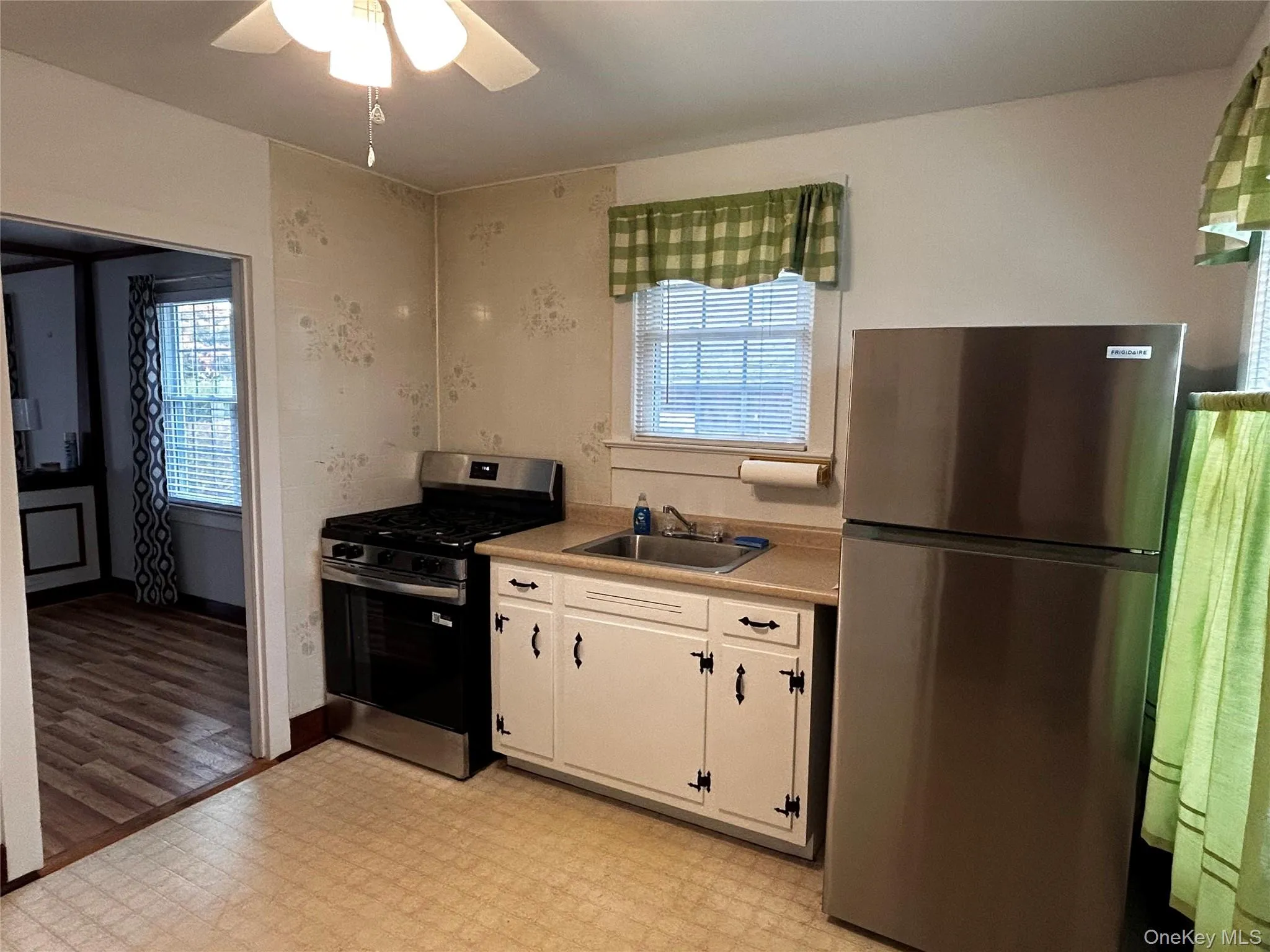 Kitchen with new appliances with stainless steel finishes, light flooring, light countertops, ceiling fan, and white cabinetry Kitchen with new appliances with stainless steel finishes, light flooring, light countertops, ceiling fan, and white cabinetry