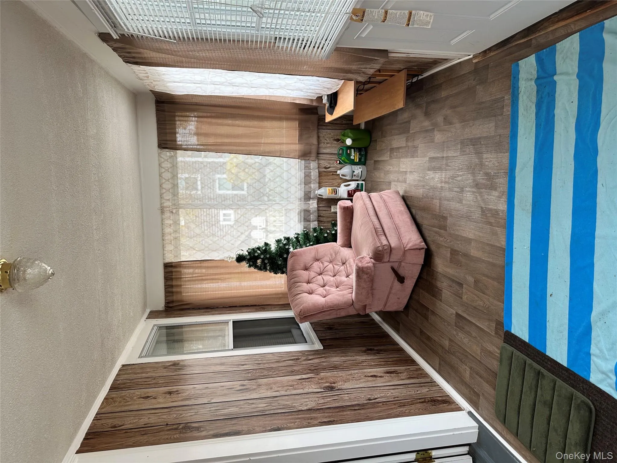 Sitting room featuring a textured ceiling, dark wood-style floors, and wooden walls Sitting room featuring a textured ceiling, dark wood-style floors, and wooden walls