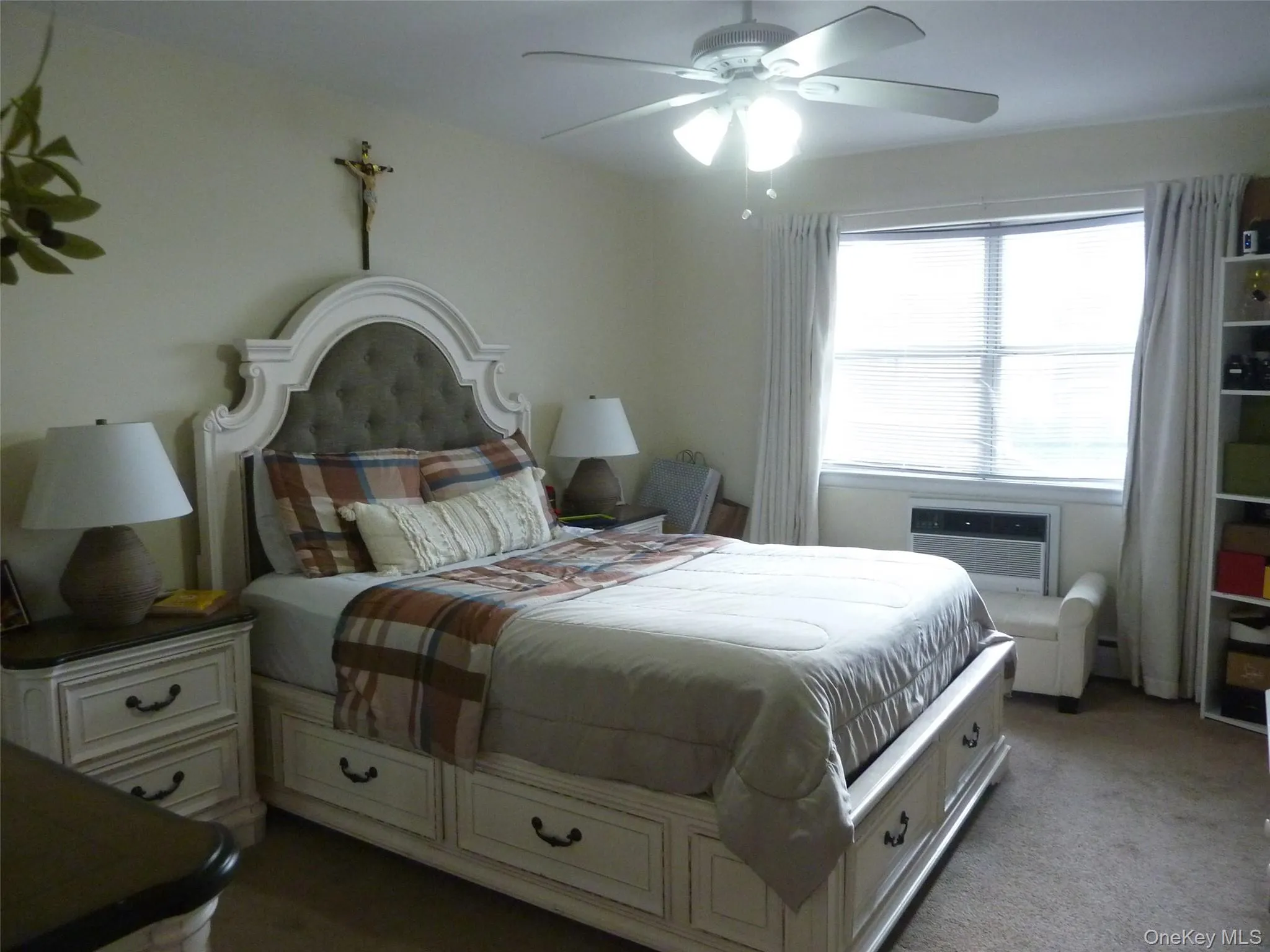 Bedroom with a ceiling fan, carpet, and a wall mounted air conditioner Bedroom with a ceiling fan, carpet, and a wall mounted air conditioner