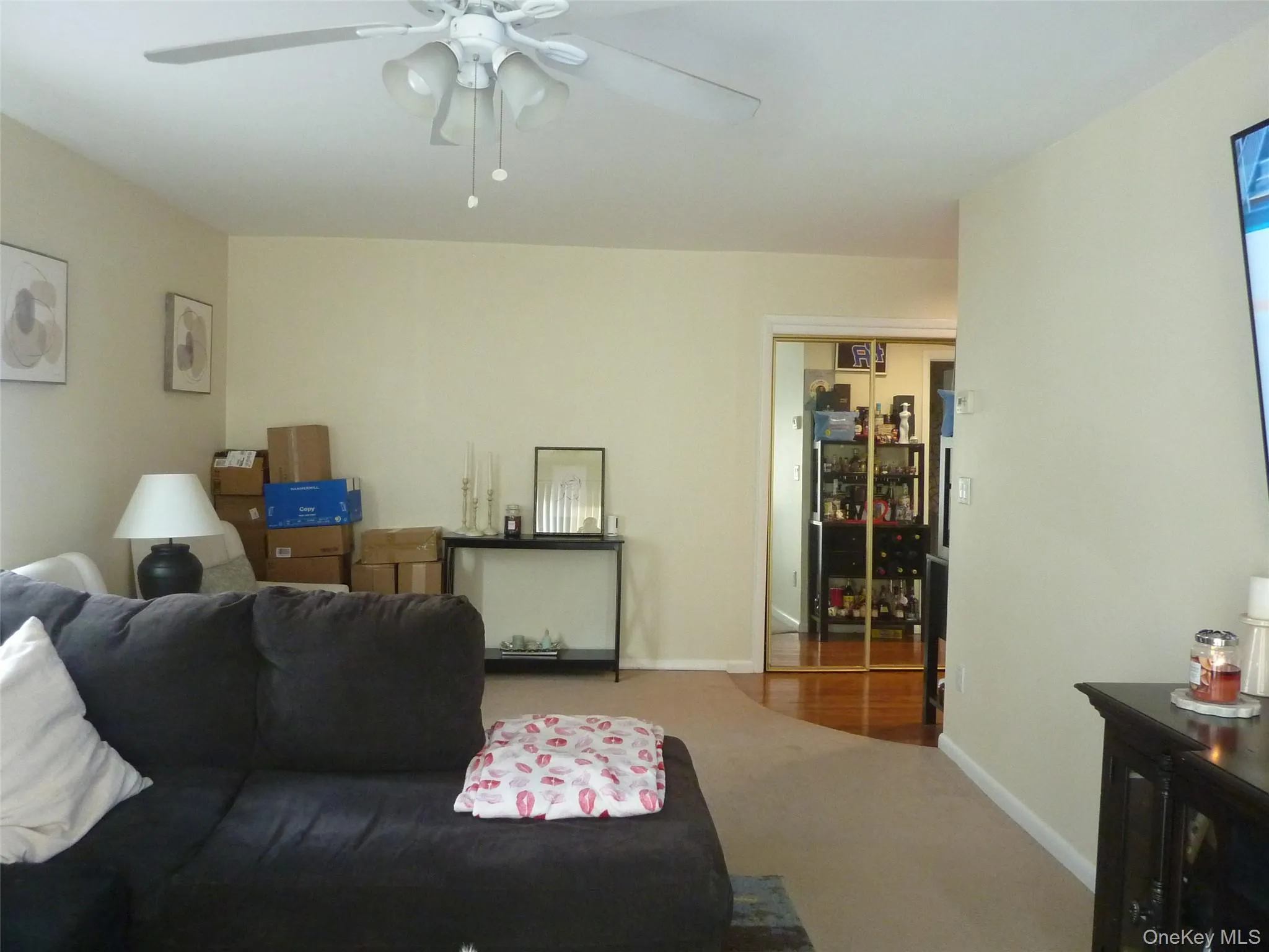 Carpeted living room featuring baseboards and ceiling fan Carpeted living room featuring baseboards and ceiling fan