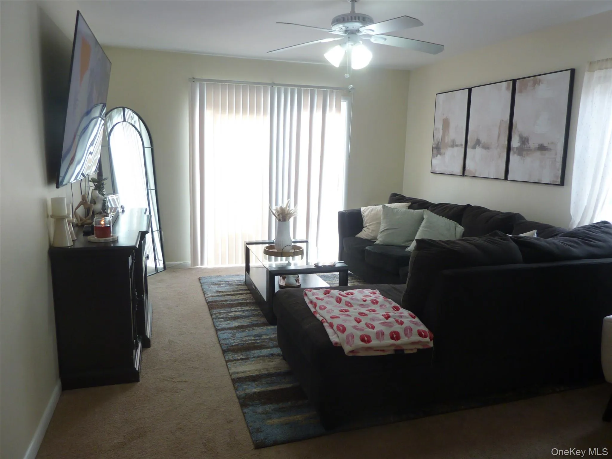 Carpeted living room featuring ceiling fan and baseboards Carpeted living room featuring ceiling fan and baseboards
