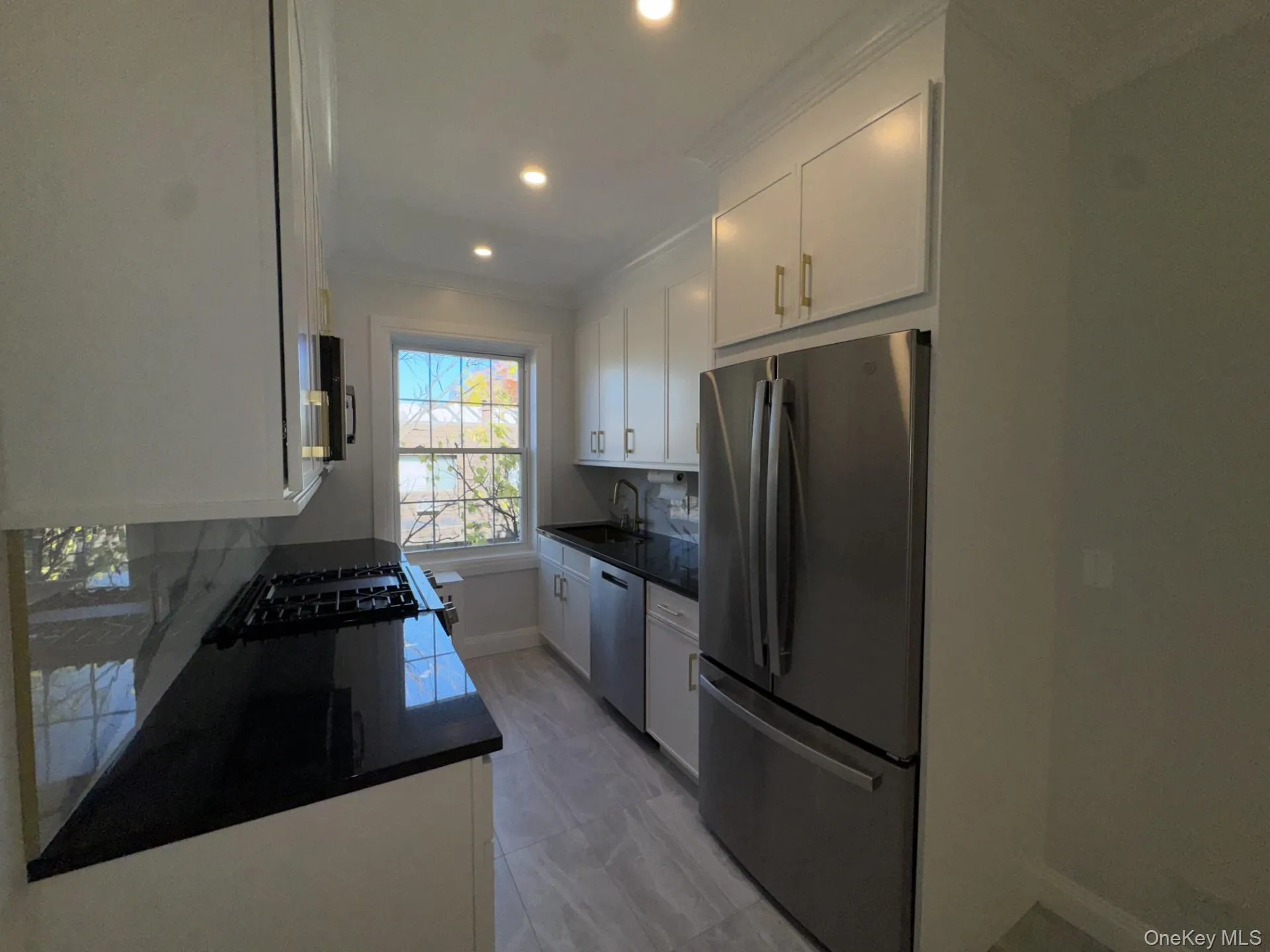 Kitchen featuring white cabinetry, stainless steel appliances, decorative backsplash, crown molding, and recessed lighting Kitchen featuring white cabinetry, stainless steel appliances, decorative backsplash, crown molding, and recessed lighting