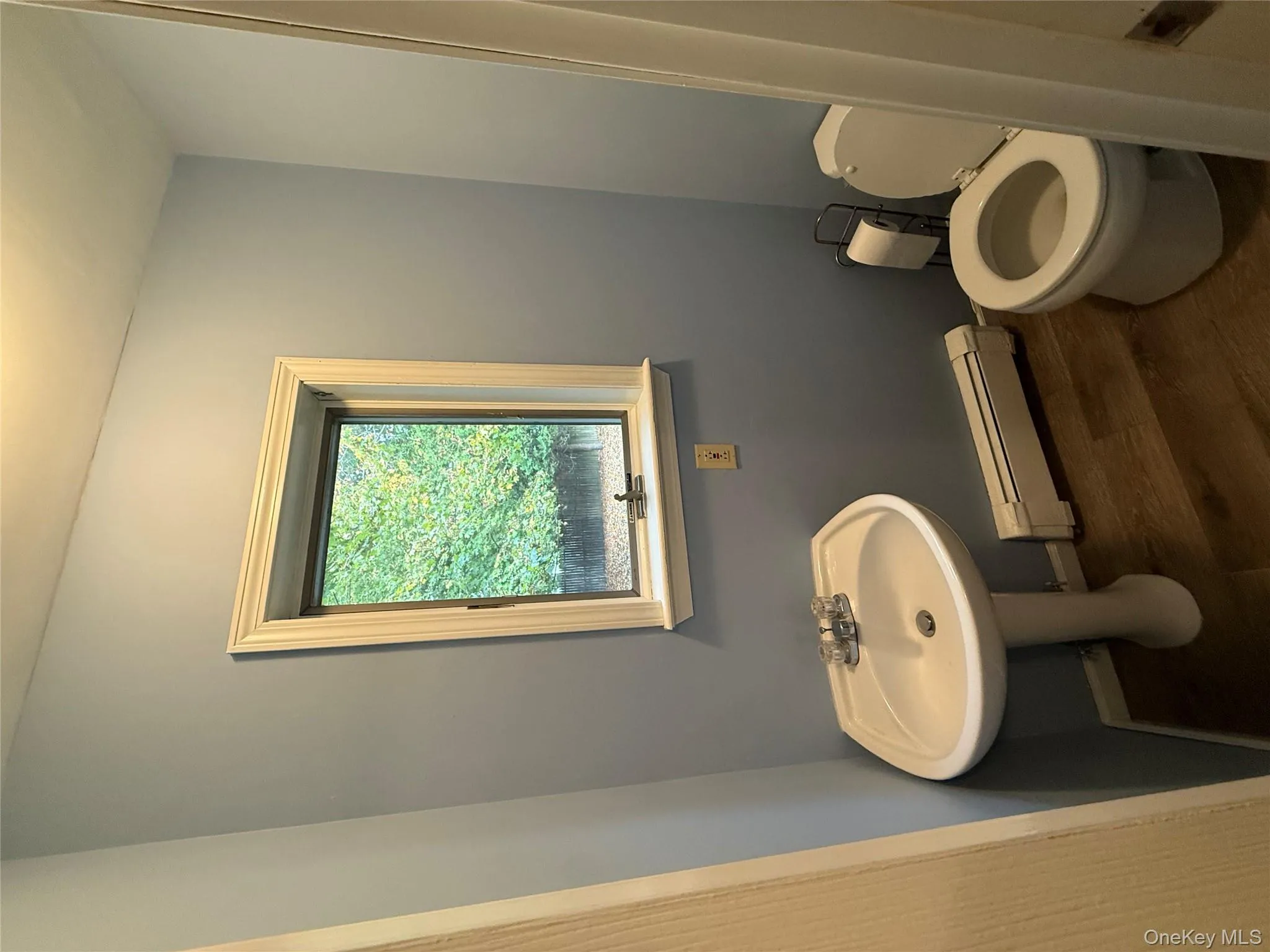 Bathroom with baseboard heating and dark wood-style floors Bathroom with baseboard heating and dark wood-style floors