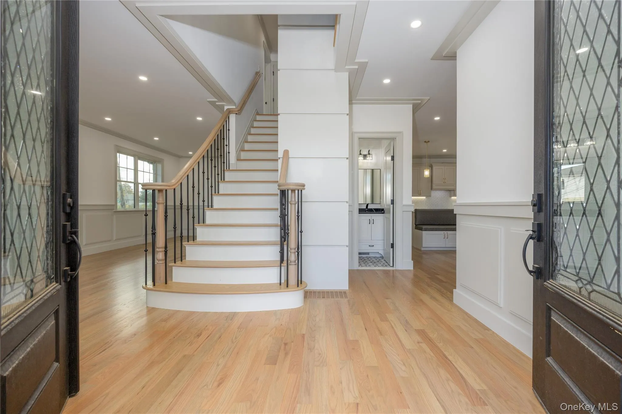 Foyer entrance featuring a decorative wall, stairs, light wood finished floors, recessed lighting, and wainscoting Foyer entrance featuring a decorative wall, stairs, light wood finished floors, recessed lighting, and wainscoting