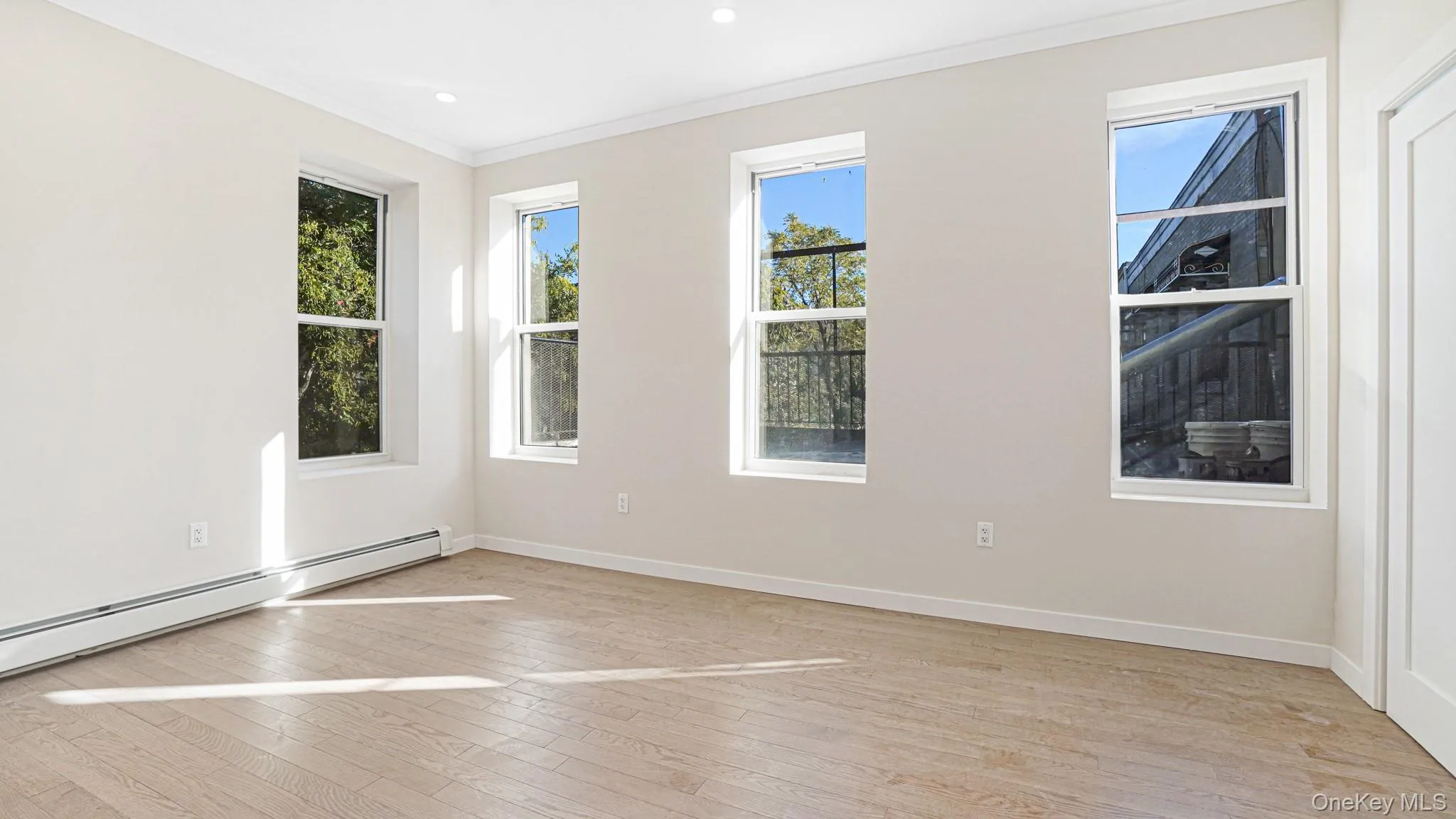 Spare room with ornamental molding, light wood finished floors, a baseboard heating unit, and recessed lighting Spare room with ornamental molding, light wood finished floors, a baseboard heating unit, and recessed lighting