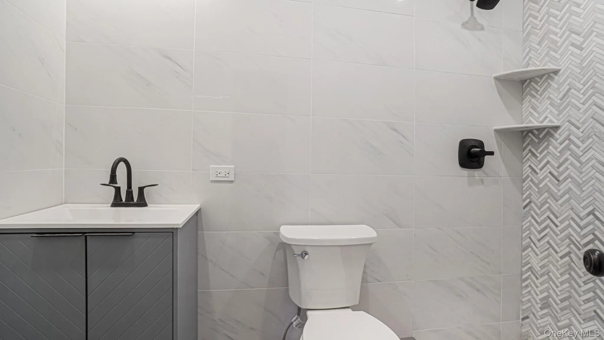 Bathroom with vanity, tiled shower, and tile walls Bathroom with vanity, tiled shower, and tile walls