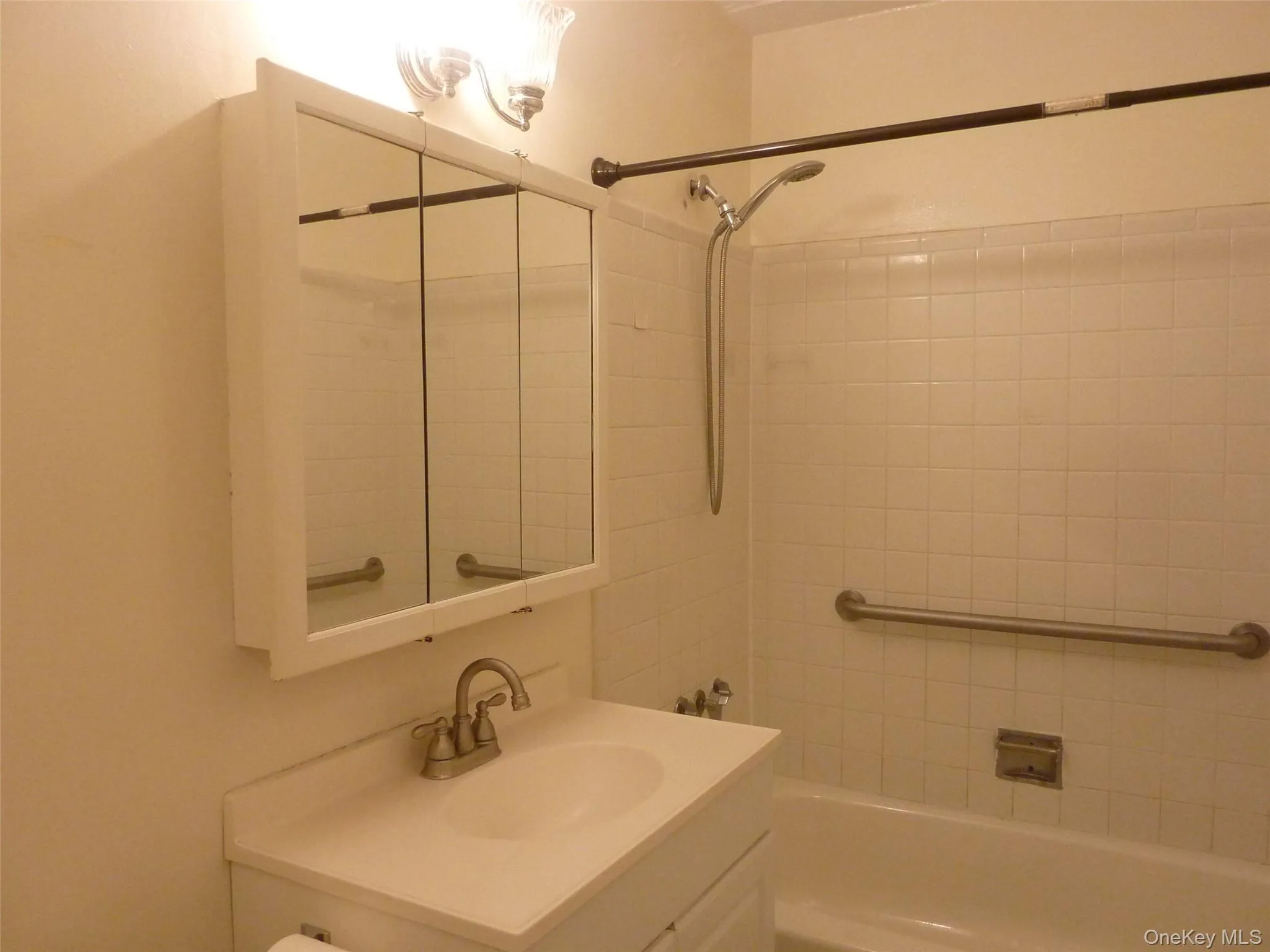 Bathroom featuring bathing tub / shower combination and vanity Bathroom featuring bathing tub / shower combination and vanity