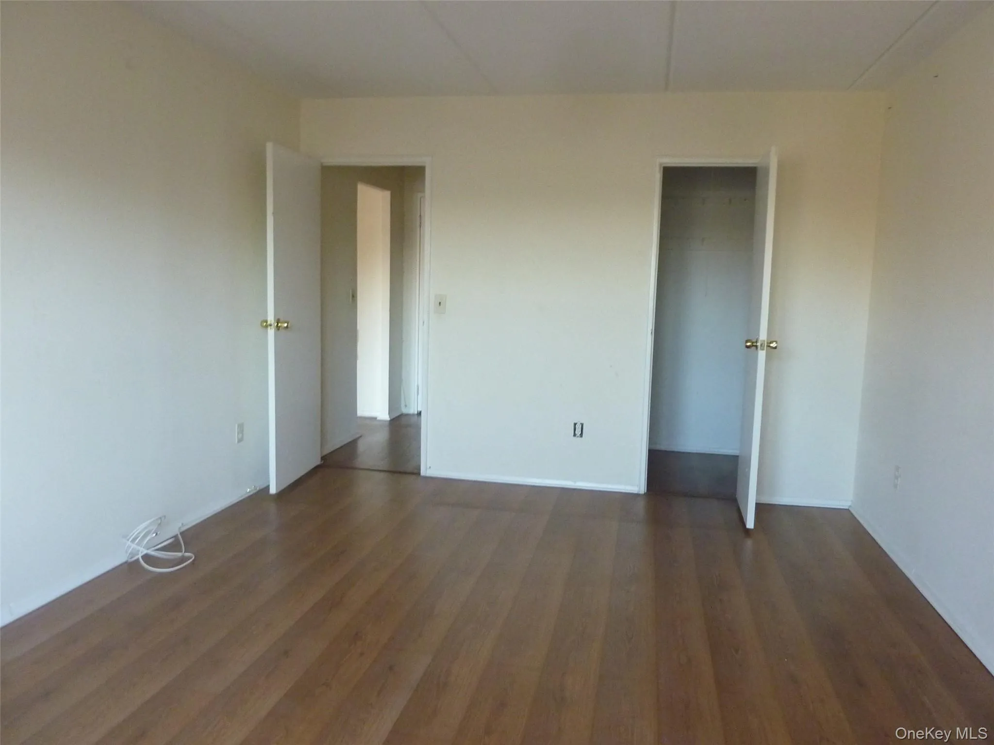 Unfurnished bedroom with a closet and dark wood-style floors Unfurnished bedroom with a closet and dark wood-style floors